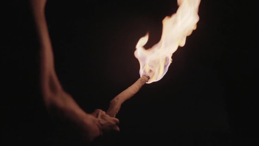 A person is holding a torch in a dark area