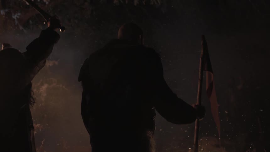 Men stand near a fire on a snowy night