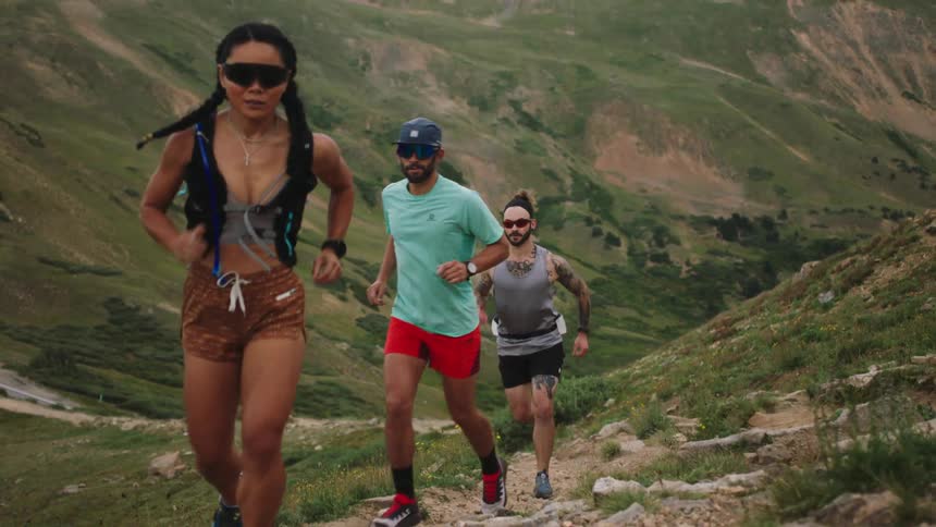 Three people run up the hill