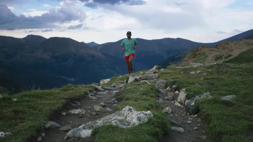 A man jogging in mountains on a summer day