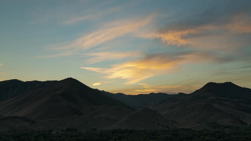 Clouds floating above a mountain range at sunrise