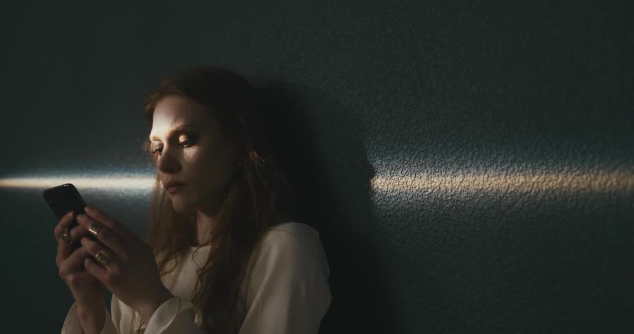 A woman looking sad while using her smartphone