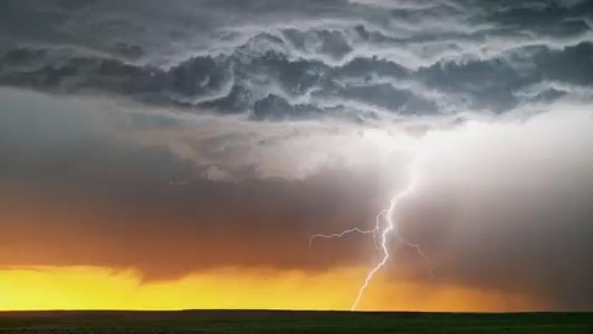 Dark storm clouds and thunder over a field in the evening
