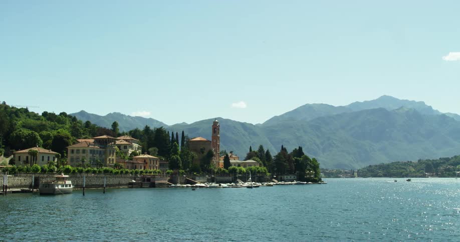 View of coastal town with distant mountain range on sunny day