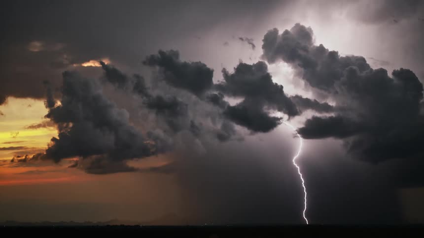 Lightning strikes behind dark clouds