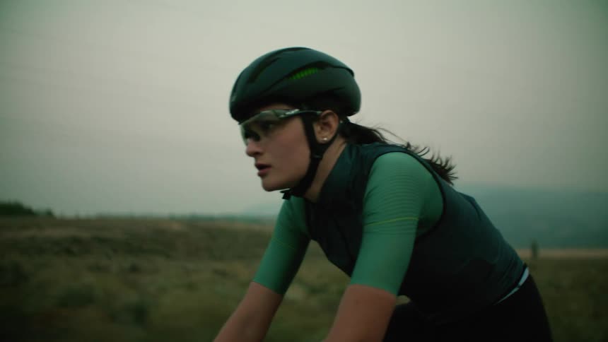 A cyclist rides down a rural highway