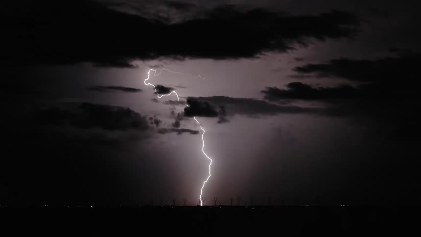 Lightning bolts crack the darkness of the night sky and light up the area with bright flashes