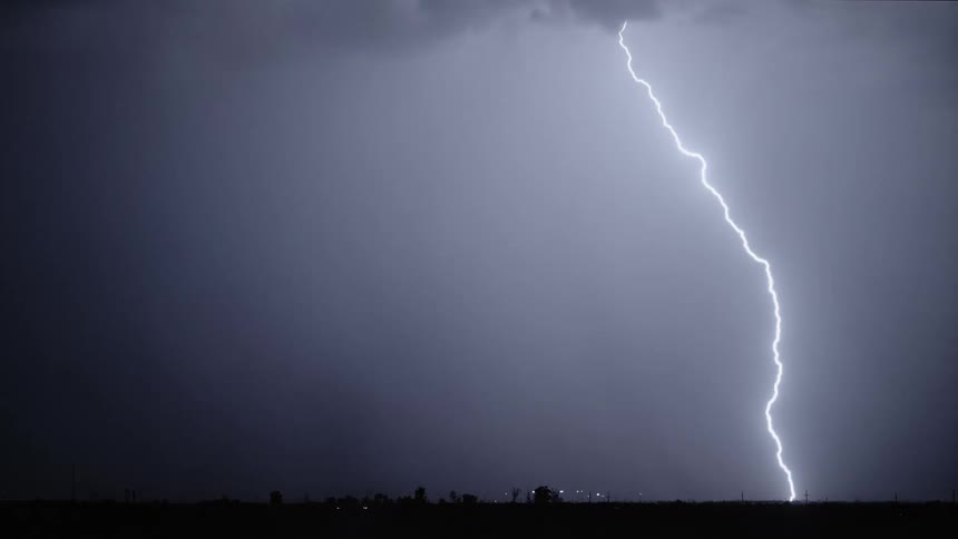 Lightning flashing in a dark night sky during a rainstorm