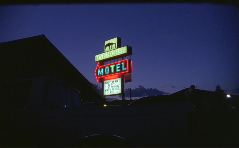A view of a vintage motel sign outdoors at blue hour in Montana shot on 16mm Film