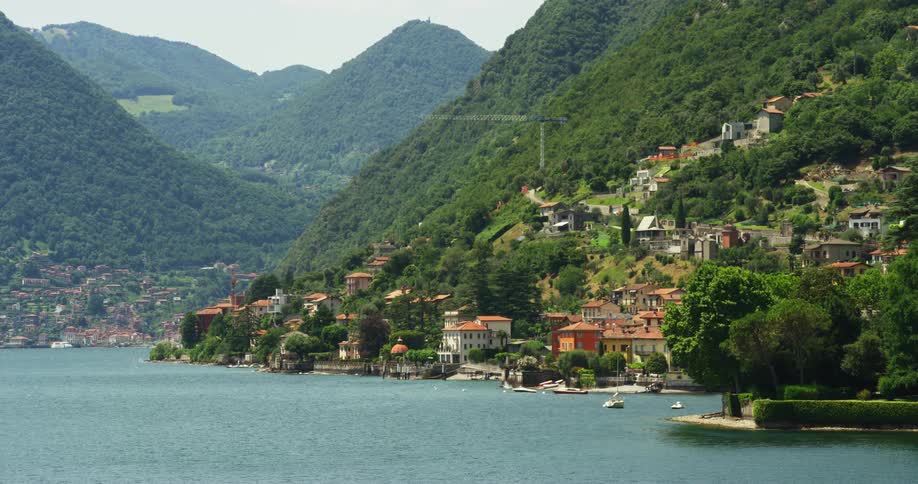 Homes on a lakeside hill with boats floating in the water