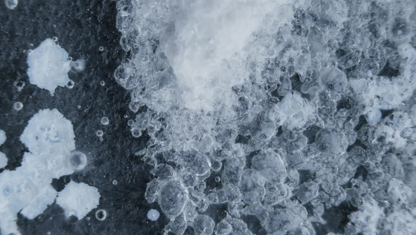 Time lapse close up of water crystals forming on the surface of bubbling water