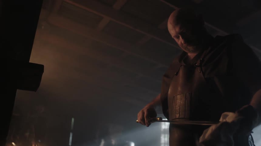 Man holding and examining the blade of a sword