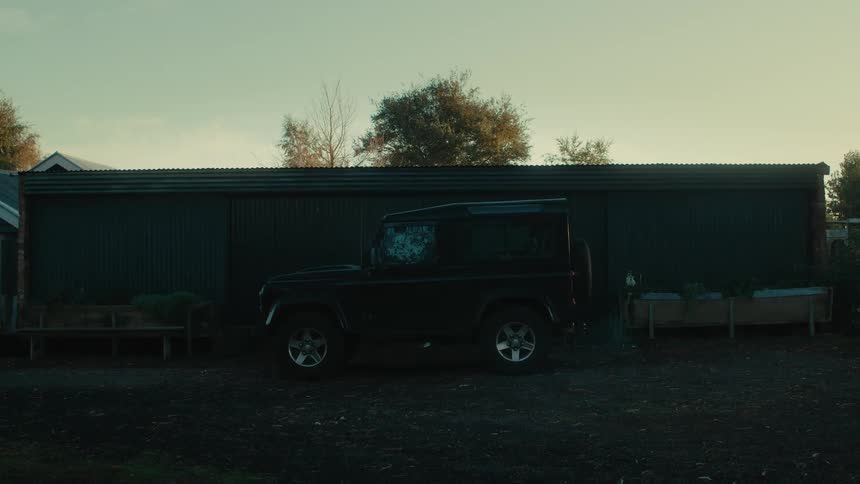 A vehicle parked outside a building slowly pulls away