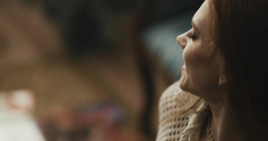 Close up of a young woman sitting on the living room floor dancing and singing