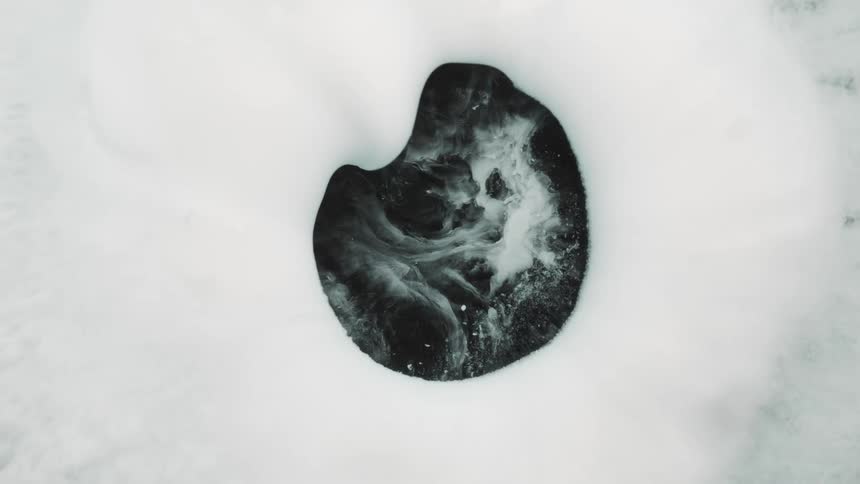 A hole is open in a white substance and white smoke comes out and then it covers the black hole