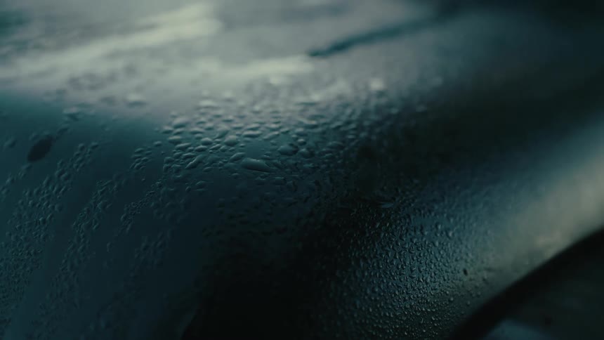 Light shines on droplets of moisture on a light blue surface