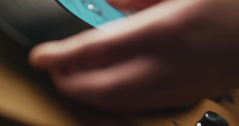 A person changing an album on a record player