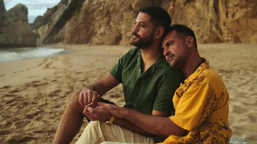 A couple sit on the beach together