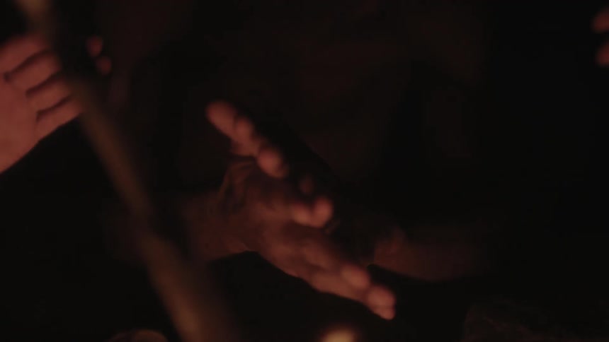 People warming their hands by a campfire