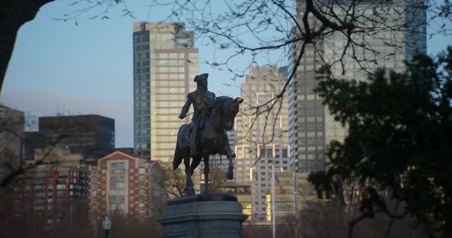 A statue of a soldier riding a horse in an urban park