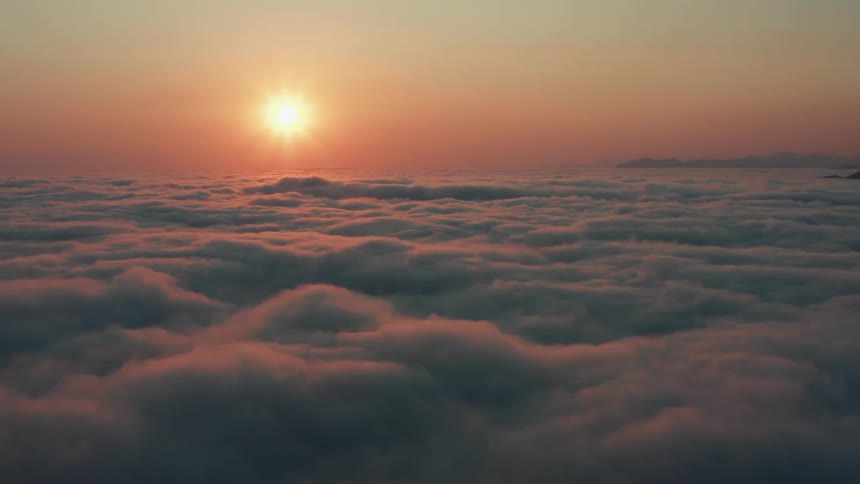 Aerial view of a the sun setting at the golden hour over the clouds