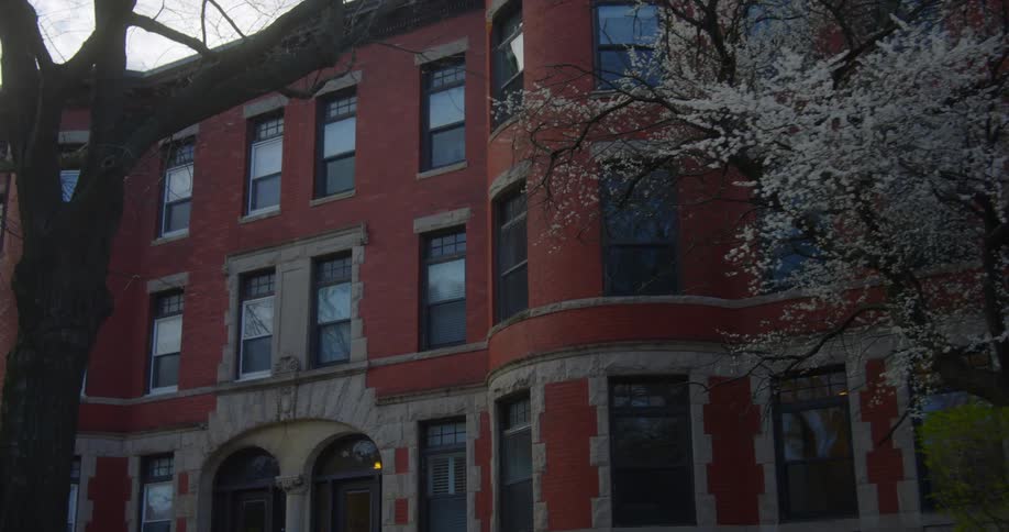 A huge brick building with several windows is shown passing by
