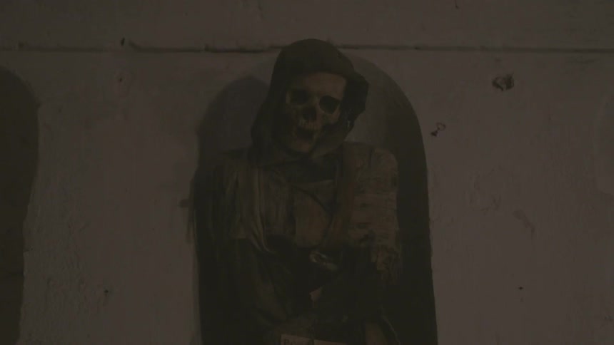 A skeleton is leaning in a crypt