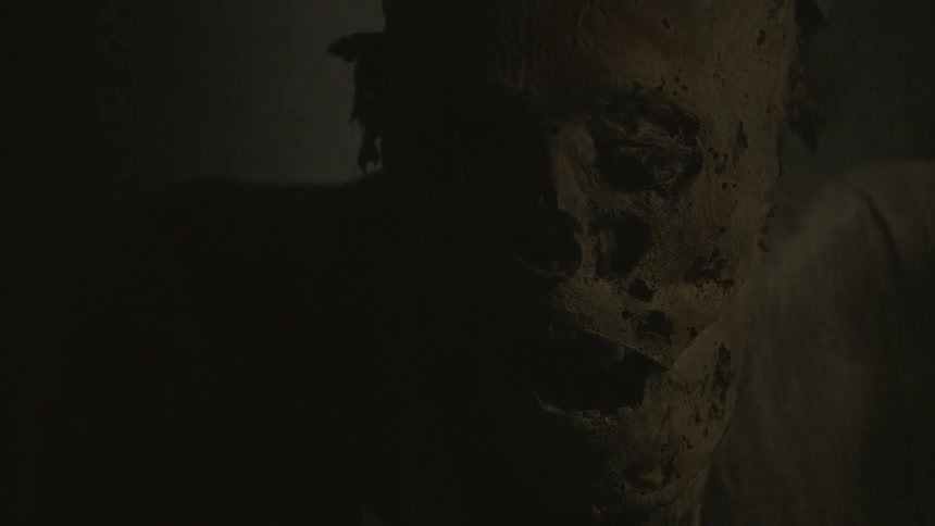 A mummified body in a dim room