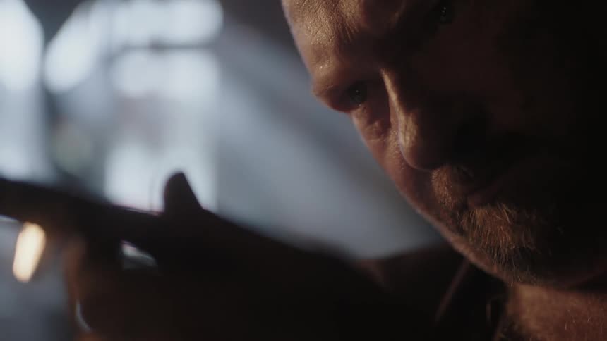 A blacksmith examines his work