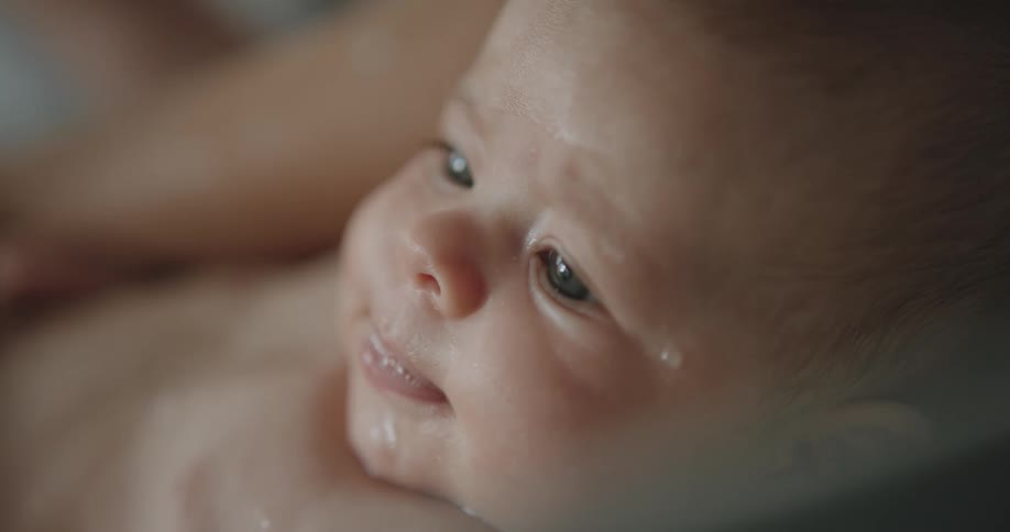 A baby is being washed with water
