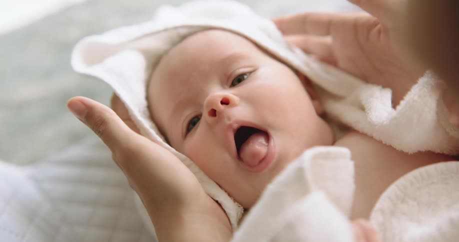 A woman towel dries a baby