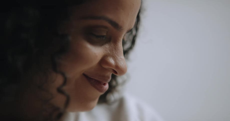 A woman smiles while looking down