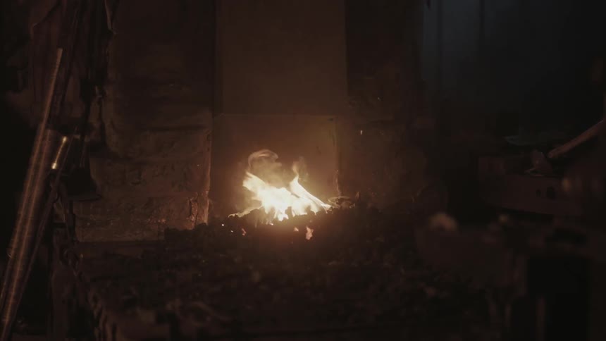 A fire burns in a blacksmith shop