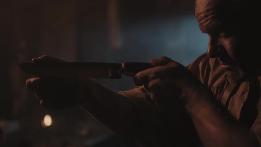 A man is examining a small blade