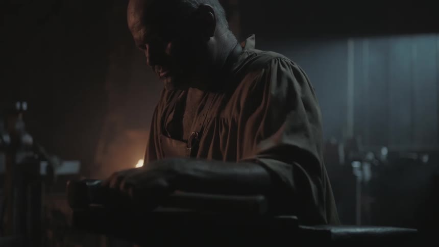 A man is leaning forward in a dark room