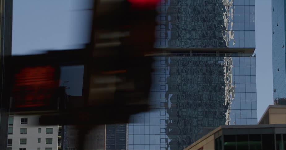 The mirror surface of a downtown building reflects the images of surrounding buildings