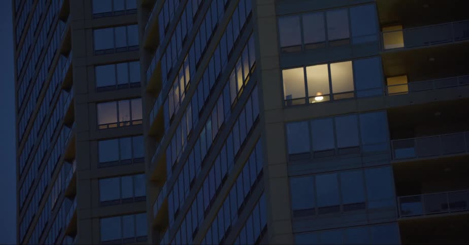 A skyscraper with illuminated windows in a city at night
