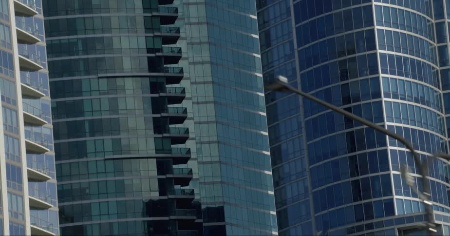 The windows of downtown buildings reflect light as they stand tall and close together in a tower block