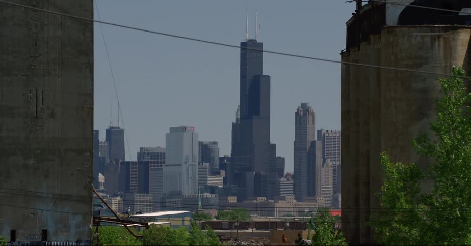 The willis tower behind skyscrapers on the chicago skyline under a deep blue sky