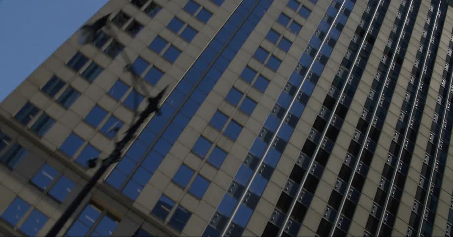 Sunlight shining on city skyscraper windows and facades on a bright blue sky day