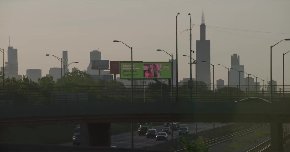 Traffic drives along controlled access highway with mist covered silhouetted skyline in background
