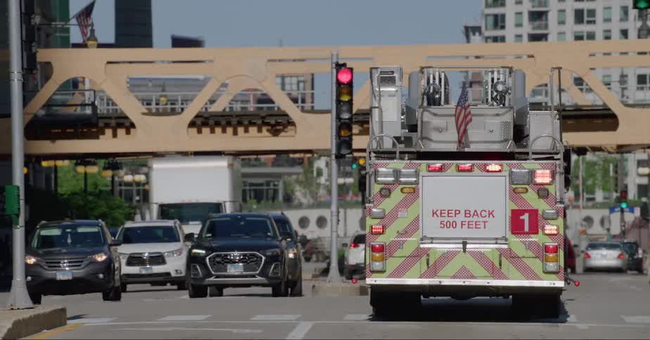 Firefighter truck driving on the streets of chicago on a bright day