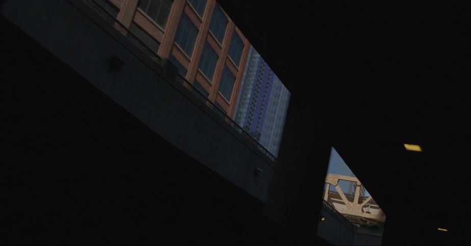 Traveling through a tunnel with a view of chicago city buildings and elevated train bridge