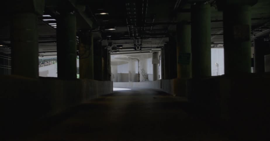 A road in a tunnel with high rise office buildings in the distance