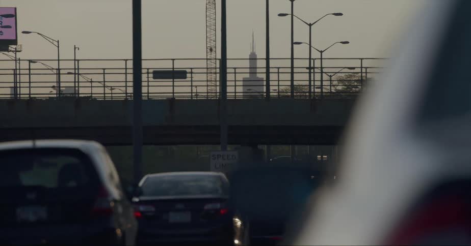 Cars and trucks traveling toward the city in stop and go traffic