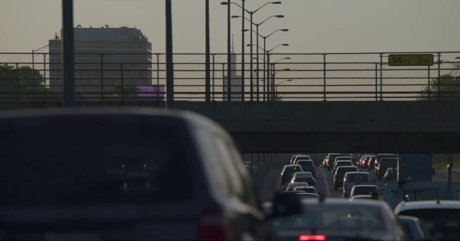 Heavy traffic sits stopped on a highway headed to downtown