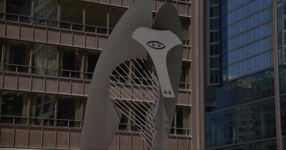 Skyscrapers near large abstract metal sculpture reflect surroundings