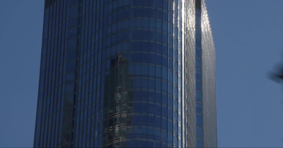 Sunlight reflects off a mirrored skyscraper