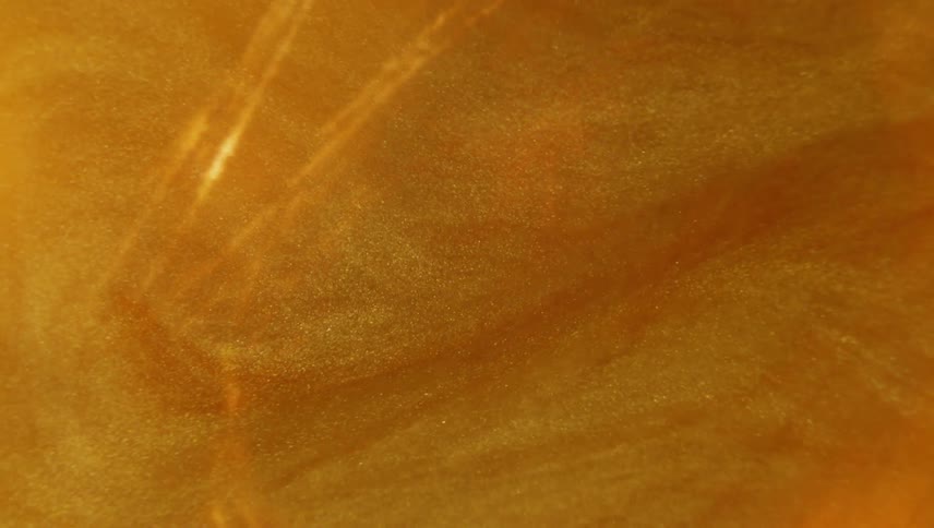 Orange light glare sits over churning orange mixture