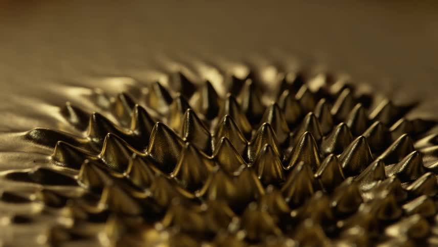 Small spikes rise from a pool of liquid chrome